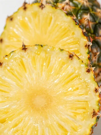 Fersk, oppskåret ananas på rustikt trebord