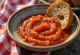 Søt mojo rojo-saus i en skål, omgitt av biter av stekt paprika