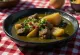 Callaloo med røkt kjøtt, grønn bladstuing servert med røykte kjøttterninger i kokosmelkbase.