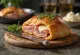 Stromboli servert med skinke, fylt med rikelig skinke og smeltet mozzarella, sprø utenpå og myk inni