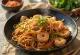 Yakisoba med scampi, en blanding av deilige nudler og grønnsaker med scampi og sesamfrø